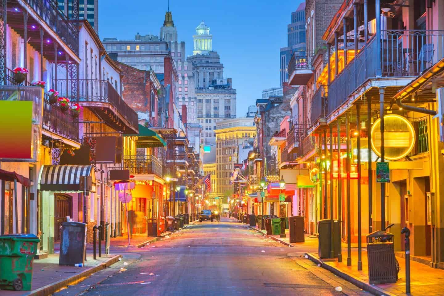 Bourbon Street at twilight, illuminated by neon lights and historic architecture, a vibrant setting for a romantic babymoon stroll in New Orleans