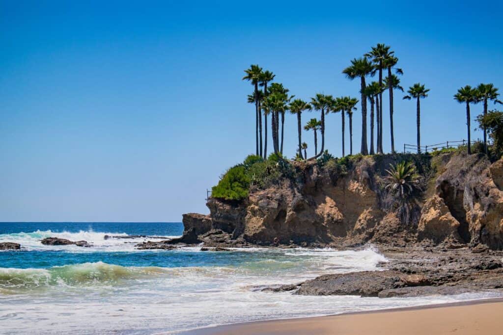 Idyllic Laguna Beach with palm trees overlooking rocky cliffs and the azure Pacific, a peaceful retreat for a California babymoon