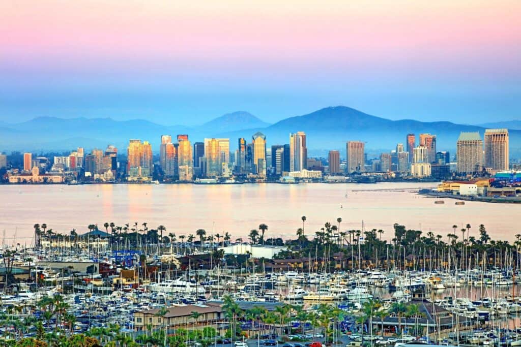 Sunrise illuminating the San Diego skyline with reflections on the water, a beautiful start to a relaxing babymoon day in California