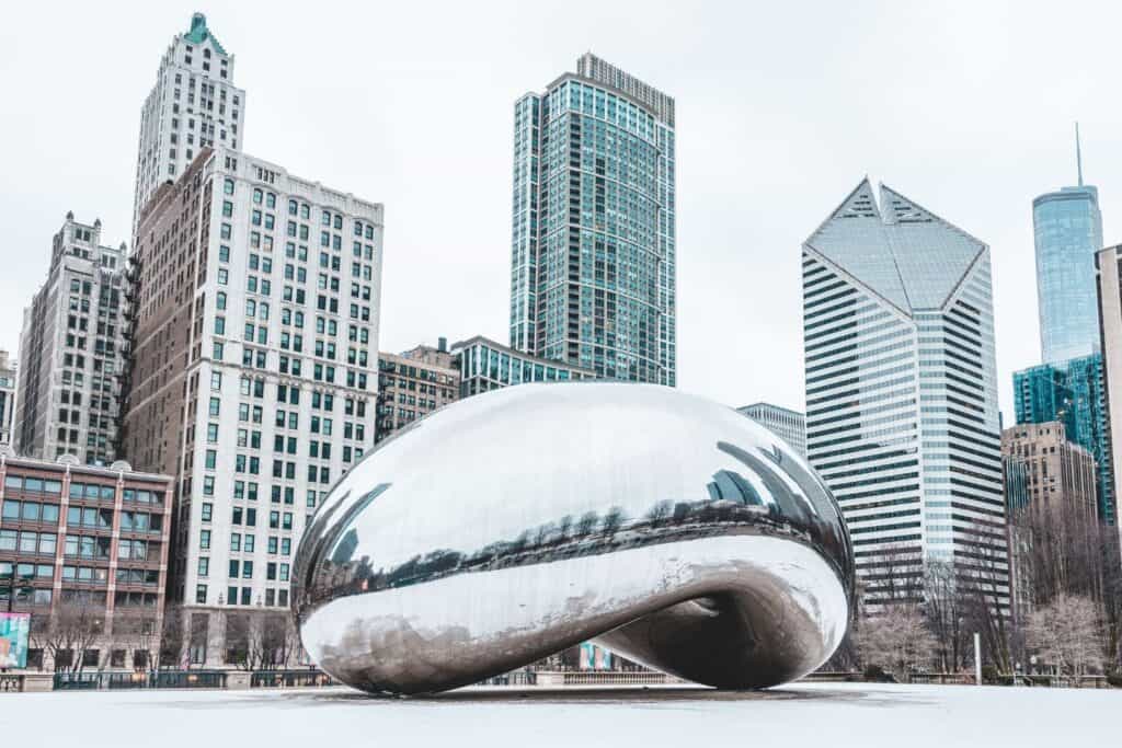 The iconic Cloud Gate sculpture, known as 'The Bean,' reflecting the winter skyline of Chicago, a picturesque spot for couples on a babymoon
