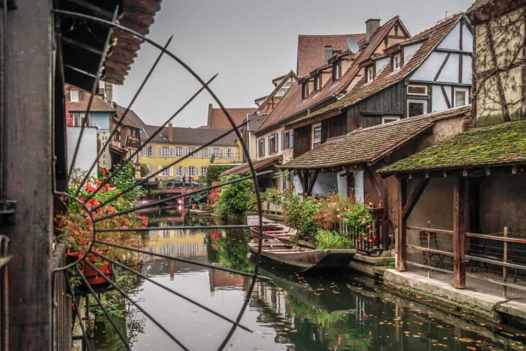 Old school house on a river in the countryside of France on a dark cloudy day.