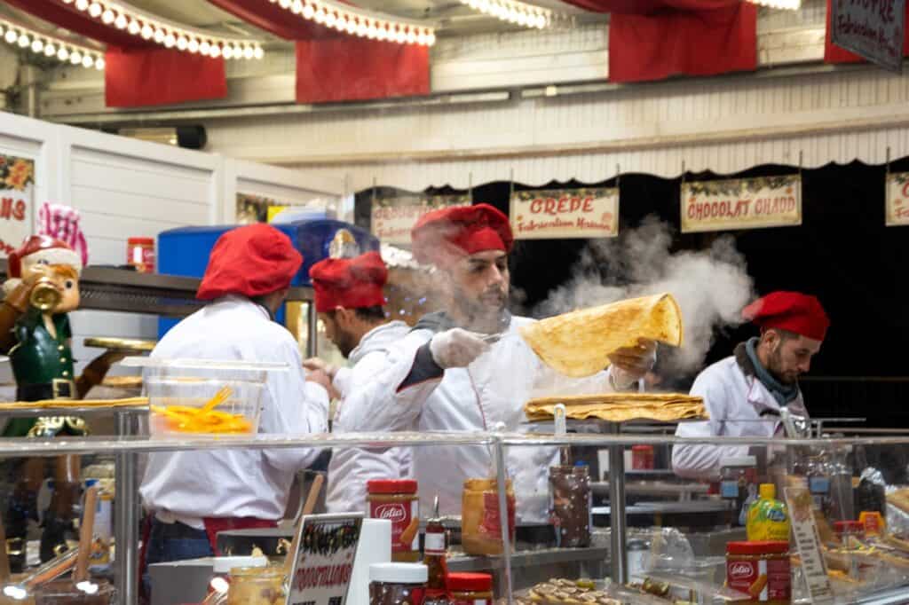 A chef with a red hat making street crepes on the streets of Paris